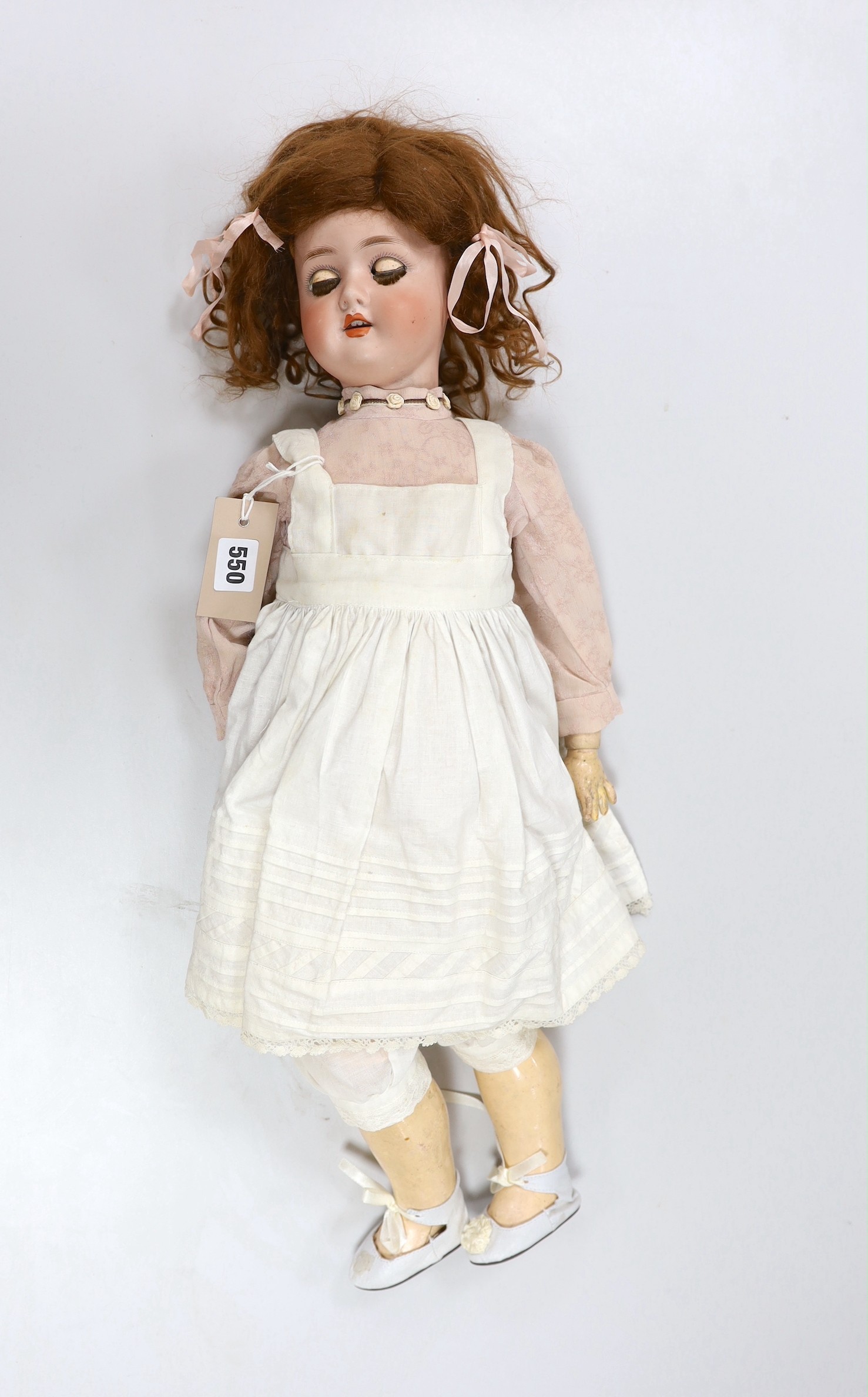 An early 20th century Schoennau & Hoffmeister bisque headed doll, 64cm